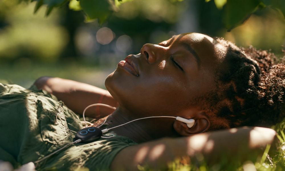 Woman using the Sensate vagus nerve device during a nighttime relaxation ritual to reduce anxiety